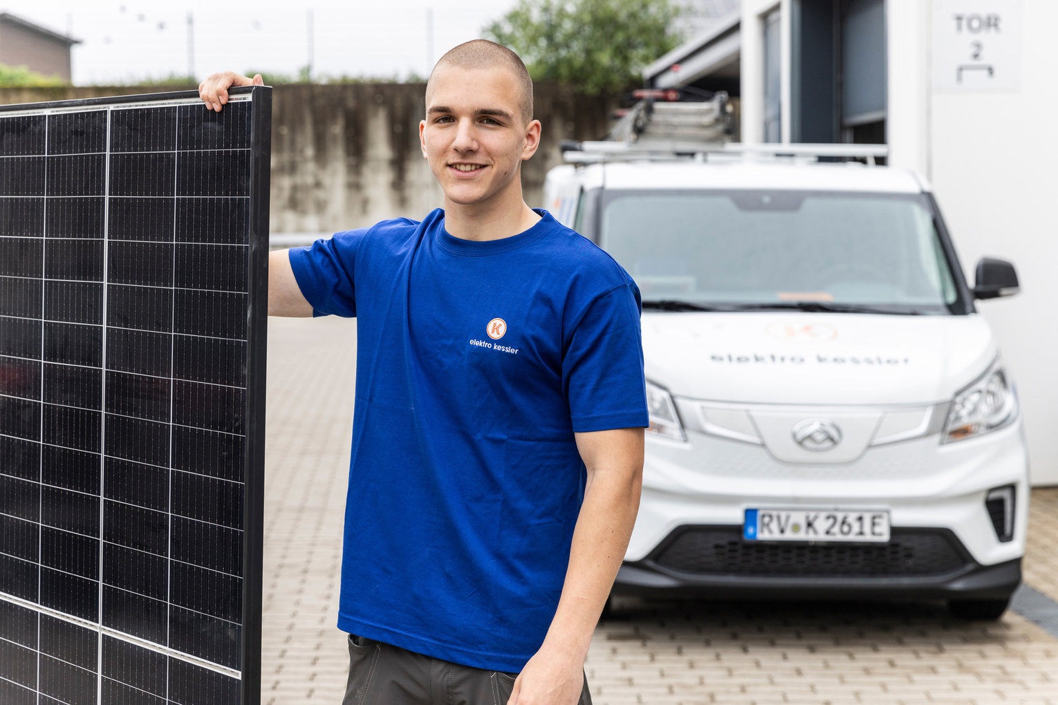 PV-Monteur Elektro Kessler Ein Mitarbeiter von Elektro Kessler steht vor einem Firmenwagen