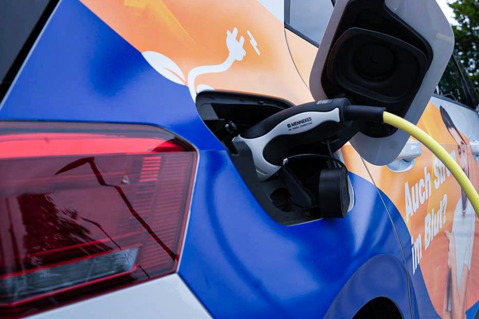 Ein Elektroauto mit "Elektro Kessler"-Branding ist mit dem Ladekabel an eine Ladestation verbunden.